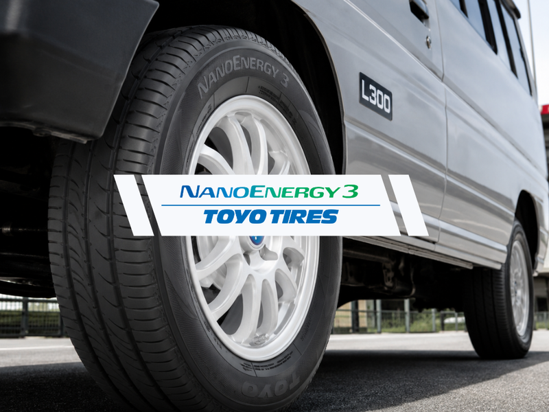 Close-up of a silver vehicle wheel with a Toyo Tire NanoEnergy3 brand overlay banner across the center.
