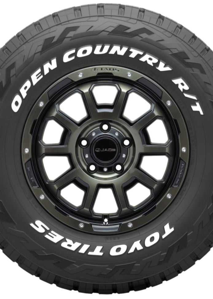 A black Toyo Tires Open Country R/T off-road tire mounted on a dark metallic multi-spoke wheel, shown against a plain white background.