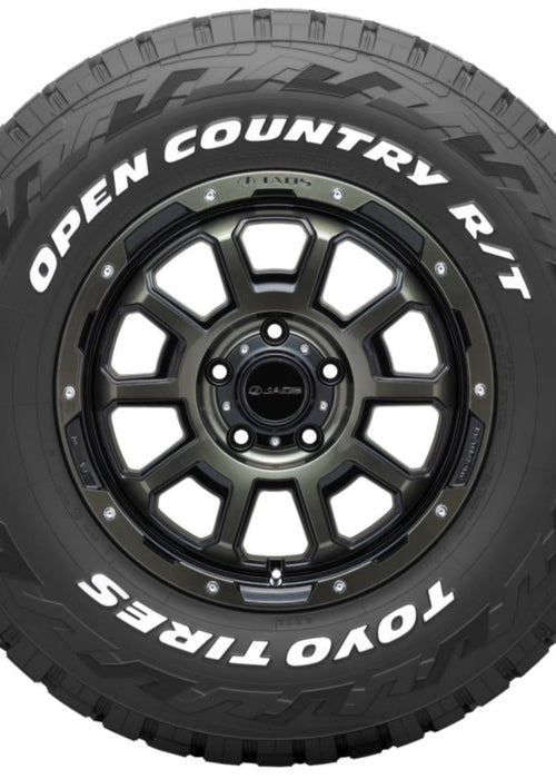 A black Toyo Tires Open Country R/T off-road tire mounted on a dark metallic multi-spoke wheel, shown against a plain white background.